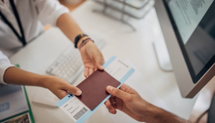 Travel agent handing client passport and boarding pass